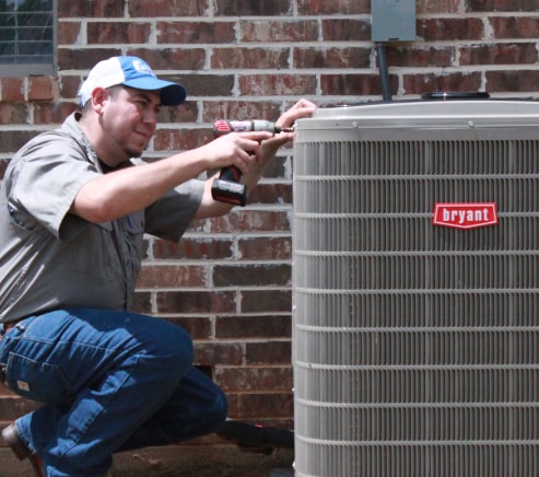 HVAC technician servicing a Bryant air conditioning unit